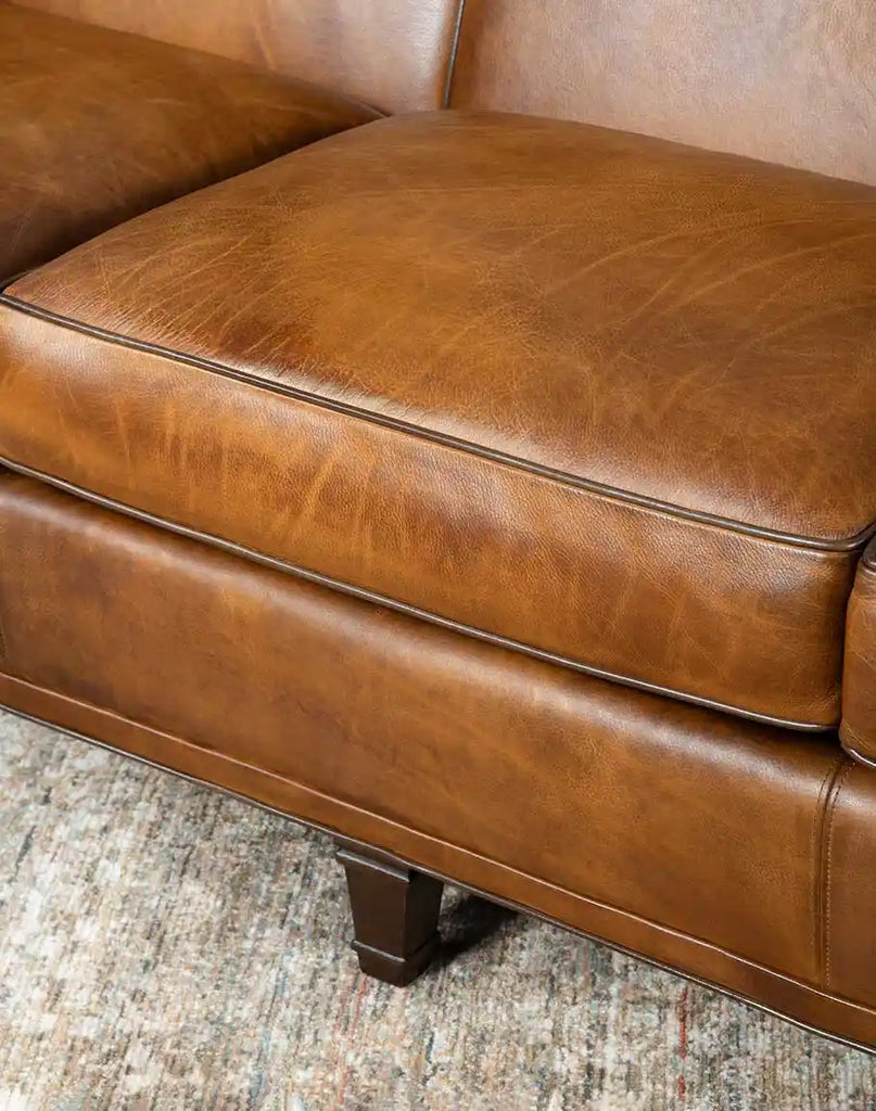 Detailed view of the Rudy Saddle Leather Sofa's plush spring down seat cushions offering ultimate comfort.