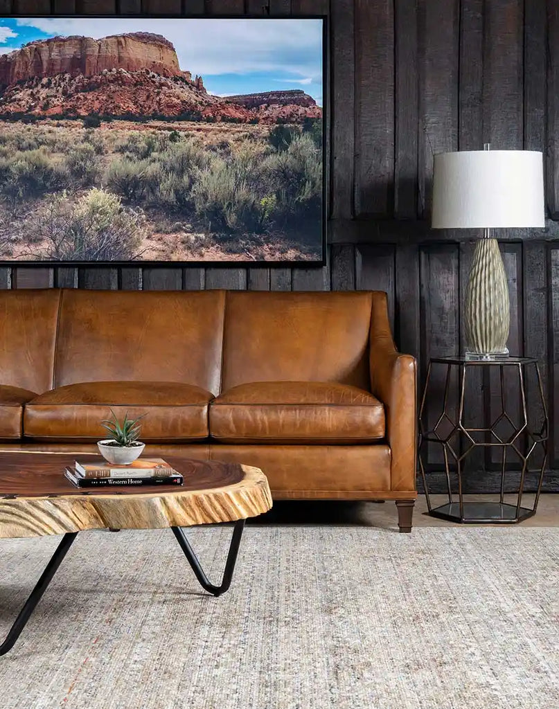 The Rudy Saddle Leather Sofa enhancing the cozy ambiance of a rustic cabin interior.