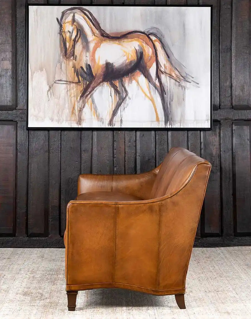 Side profile of the Rudy Saddle Leather Sofa emphasizing its sleek arm design and tailored appearance.