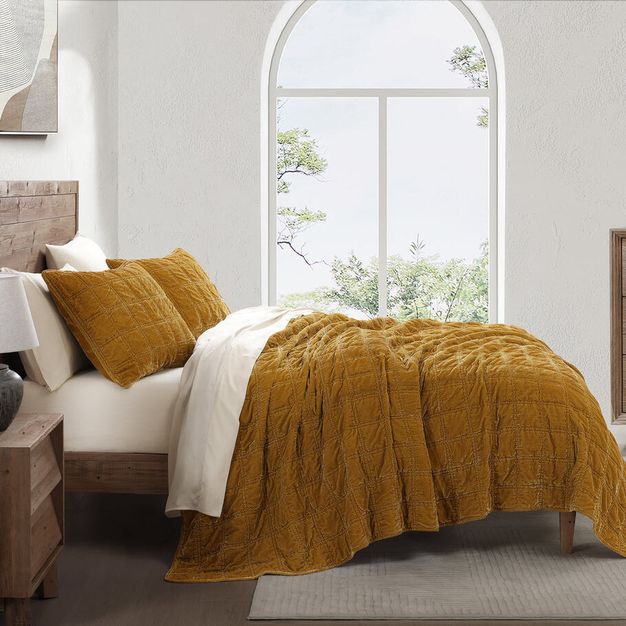 Saffron Faux Silk Velvet Quilt Set styled in a contemporary bedroom, complementing neutral tones and minimalist décor.