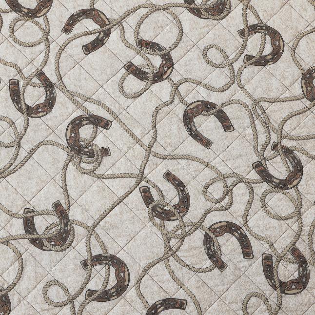 Rear view of the quilt showing the Pierre print with playful horseshoes and rope designs on a cream background.