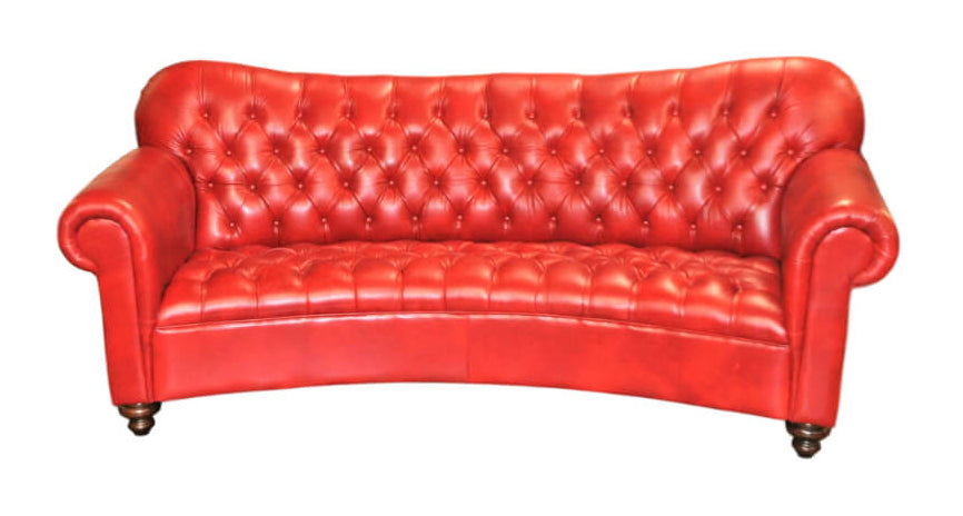 Red leather conversational style sofa with curvd back, tufted seat and tufted seatback on a white background.