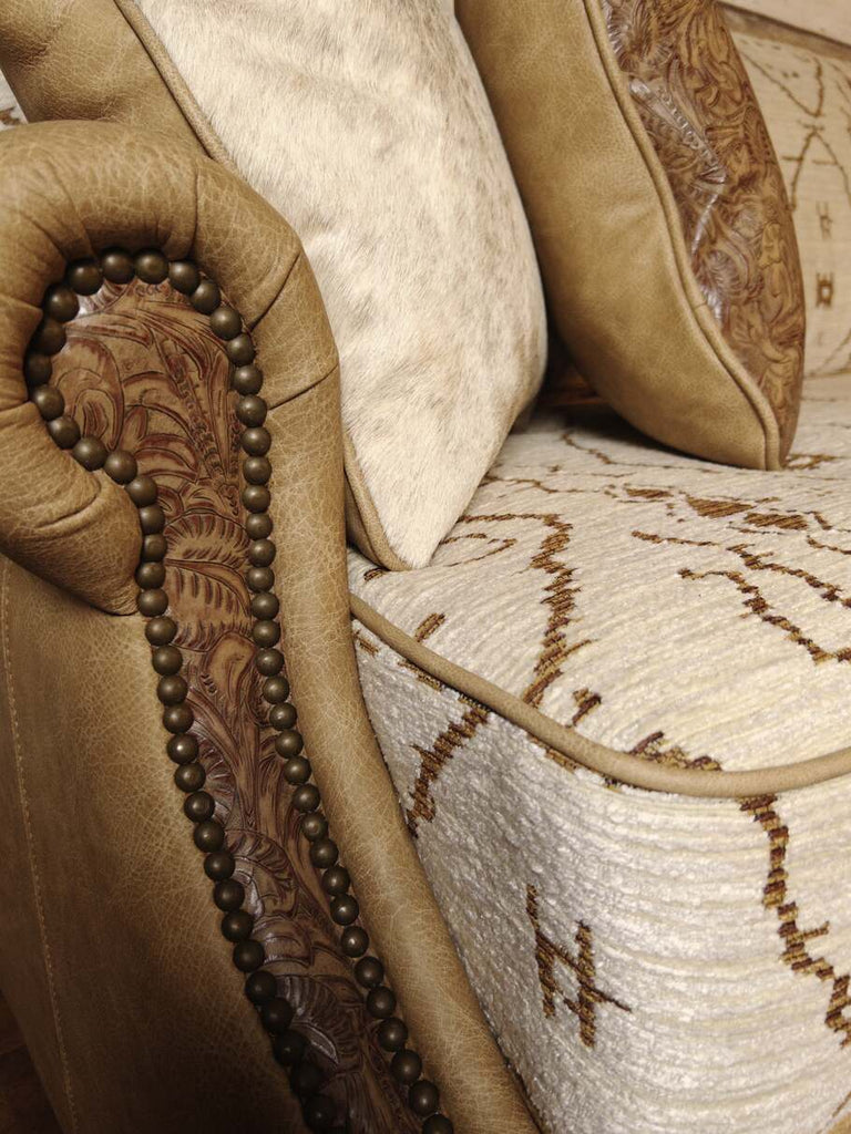 Detailed view of The Highlands Sofa's rolled armrest featuring Floral Brown Sugar leather accent.