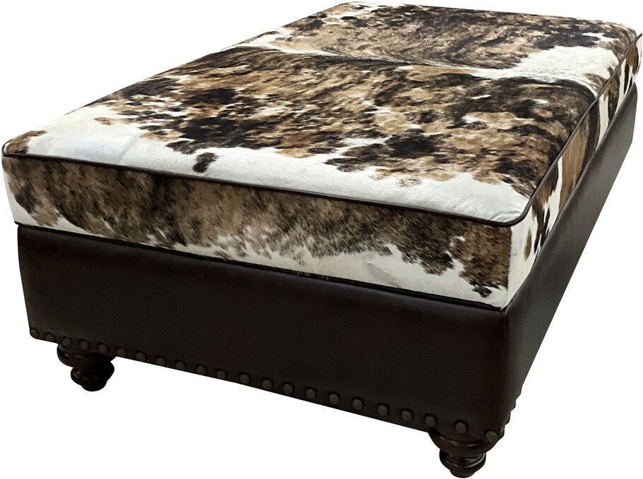 Angled perspective of The Highlands Storage Ottoman highlighting the combination of brindle cowhide top and distressed leather sides.