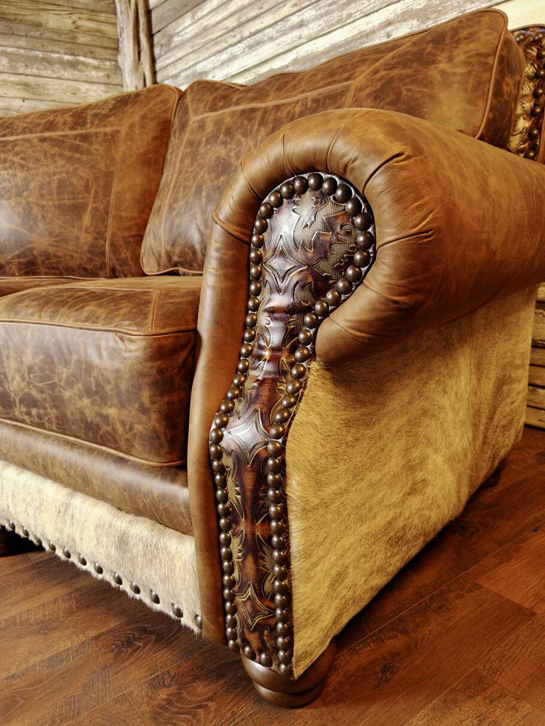 A close-up of the sectional’s armrest, highlighting the Del Rio accent leather, intricate stitching, and elegant curved shape for a classic Western touch.