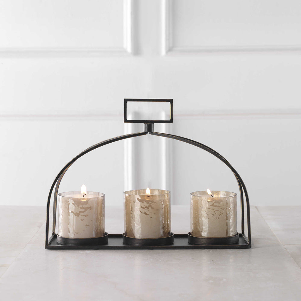 Elegant tabletop setup showcasing the bronze candleholder with lit candles for ambiance.