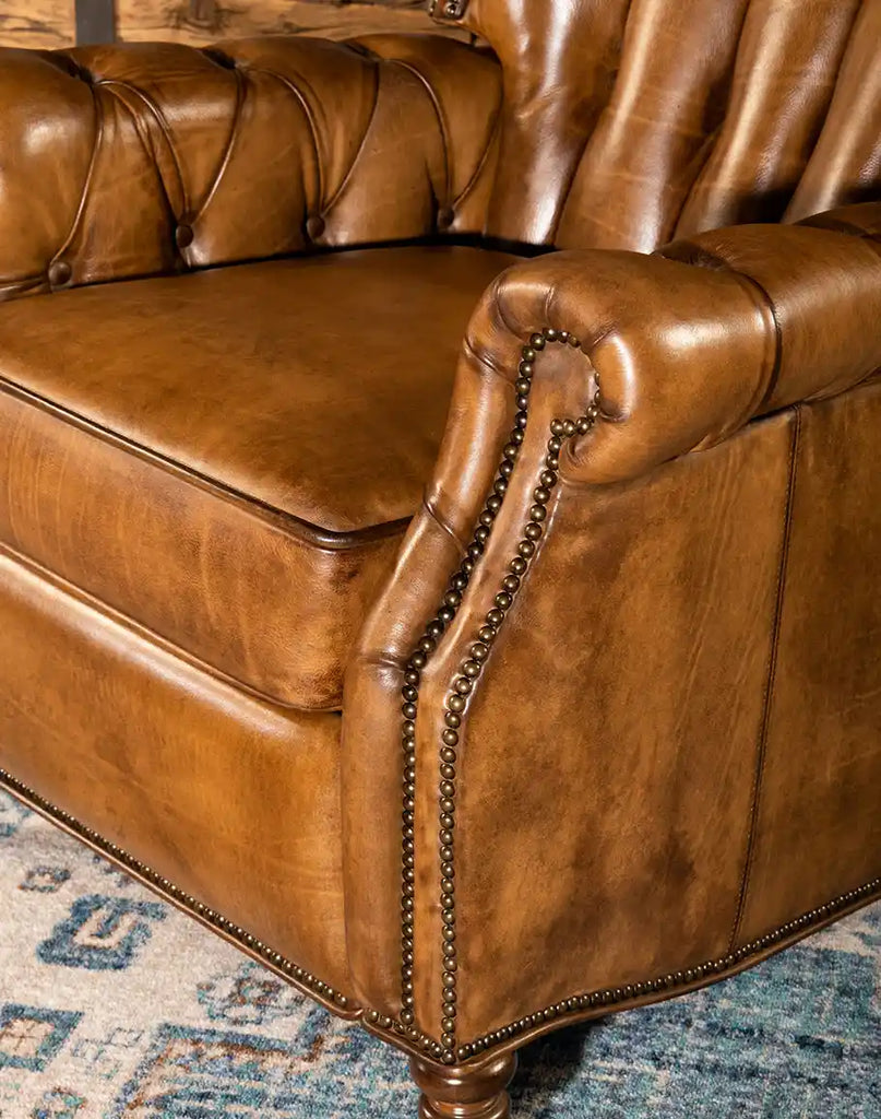 Focused view on the elegant brass nailhead trim and padded armrests, adding a refined touch to the chair’s design.