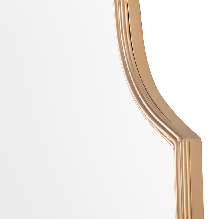 Close up of gold-framed mirror on a white background